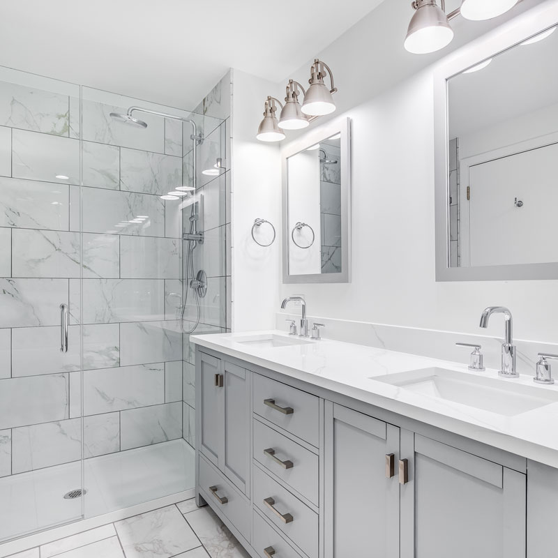 Bright bathroom remodel with tile shower, double vanity, and updated lighting.