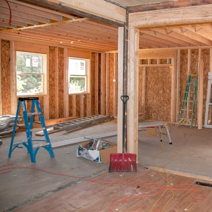 Home addition framing under construction with new walls and ceiling joists in place.